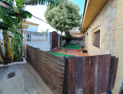 a wooden fence in front of a house with a yard at GirasolesV in Sanlúcar de Barrameda