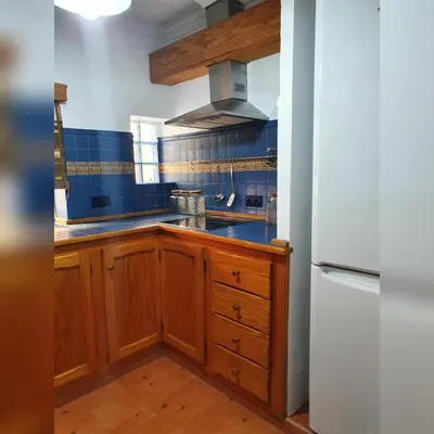 a kitchen with wooden cabinets and a white refrigerator at GirasolesV in Sanlúcar de Barrameda