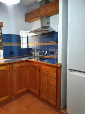 a kitchen with wooden cabinets and a white refrigerator at GirasolesV in Sanlúcar de Barrameda
