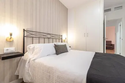 a bedroom with a large bed with white sheets at Allo Apartments Francos I Centro 2 Habitaciones in Jerez de la Frontera