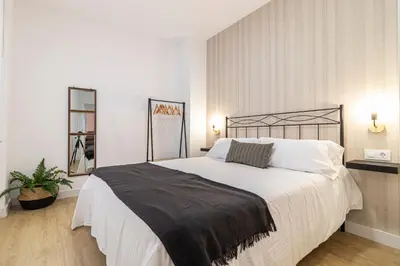 a bedroom with a large bed with white sheets at Allo Apartments Francos I Centro 2 Habitaciones in Jerez de la Frontera