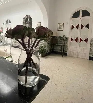 a vase filled with water and flowers on a table at HOSTAL LA CRUZ 1872 in Chipiona