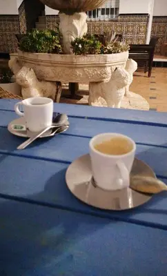 a cup of coffee sitting on a table at HOSTAL LA CRUZ 1872 in Chipiona