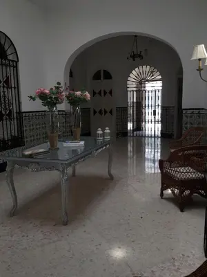 a living room with a table with flowers on it at HOSTAL LA CRUZ 1872 in Chipiona