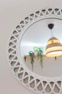a white rattan mirror with a shell pendant at Apartamento El NOBLE by Cadiz4Rentals in Cádiz