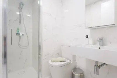 a white bathroom with a shower and a toilet at Apartamento El NOBLE by Cadiz4Rentals in Cádiz