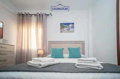 a bedroom with a bed with towels on it at Piso Nao Victoria in Sanlúcar de Barrameda