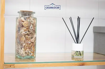 a glass jar filled with shells and a vase on a table at Piso Nao Victoria in Sanlúcar de Barrameda