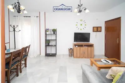a living room with a couch and a table and a tv at Piso Nao Victoria in Sanlúcar de Barrameda