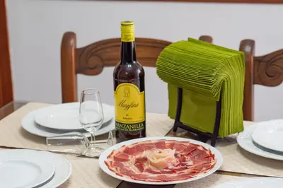 a bottle of wine and a plate of food on a table at Piso Nao Victoria in Sanlúcar de Barrameda