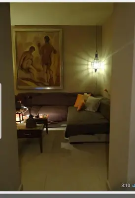 a living room with a couch and a painting on the wall at habitacion en casa kenya in Jerez de la Frontera