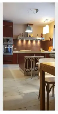 a kitchen with a counter with chairs and a table at habitacion en casa kenya in Jerez de la Frontera