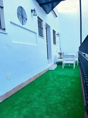 a room with a green floor and a clock on the wall at Casa Palacio Sanlúcar Home in Sanlúcar de Barrameda
