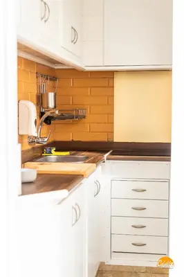 a kitchen with white cabinets and a sink at Apartamento Encanto Gaditano con Terraza by Cádiz Time in Cádiz