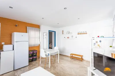 a kitchen with a white refrigerator and a table at Apartamento Encanto Gaditano con Terraza by Cádiz Time in Cádiz