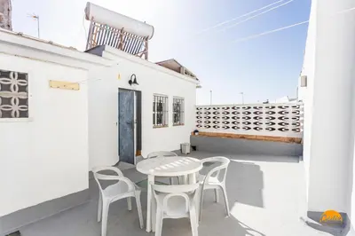 a white patio with a table and chairs at Apartamento Encanto Gaditano con Terraza by Cádiz Time in Cádiz