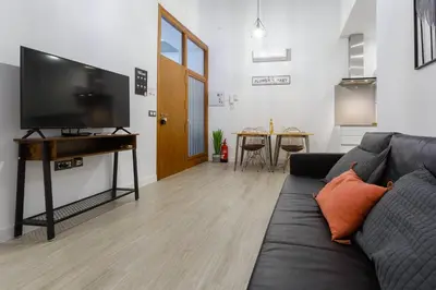a living room with a couch and a flat screen tv at CRUISE Adapted Apartment by Cadiz4Rentals in Cádiz