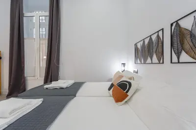 a white bedroom with a bed with a pillow on it at CRUISE Adapted Apartment by Cadiz4Rentals in Cádiz
