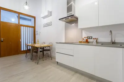a kitchen with white cabinets and a wooden table at CRUISE Adapted Apartment by Cadiz4Rentals in Cádiz