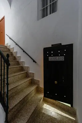 a black door with a sign on it next to stairs at CRUISE Adapted Apartment by Cadiz4Rentals in Cádiz