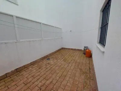 an empty room with a brick floor next to a wall at Piso Bajo Guía in Sanlúcar de Barrameda