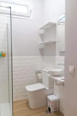 a white bathroom with a toilet and a sink at Apartamentos El Alcazar de Jerez in Jerez de la Frontera