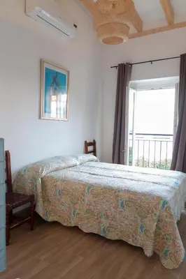 a bedroom with a bed and a large window at Apartamentos El Alcazar de Jerez in Jerez de la Frontera