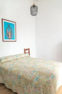 a bedroom with a bed with a colorful comforter at Apartamentos El Alcazar de Jerez in Jerez de la Frontera