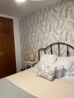 a bedroom with a bed with a floral wallpaper at Casa trillo in Sanlúcar de Barrameda