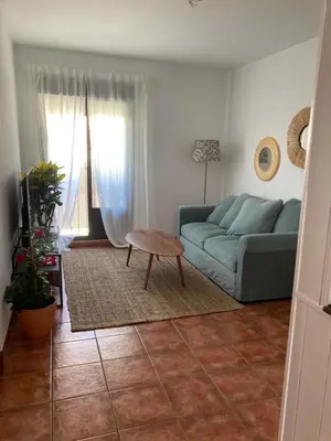 a living room with a blue couch and a table at Casa trillo in Sanlúcar de Barrameda