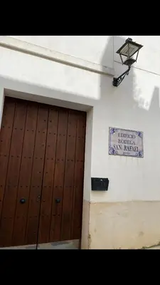 a building with a wooden door and a sign on it at Casa trillo in Sanlúcar de Barrameda