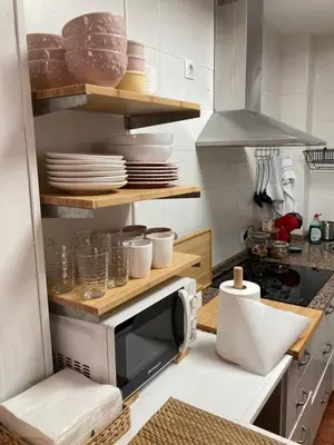 a kitchen with a microwave and plates on shelves at Casa trillo in Sanlúcar de Barrameda