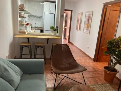 a living room with a couch and a kitchen at Casa trillo in Sanlúcar de Barrameda