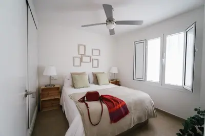 a white bedroom with a bed with a purse on it at Eva Recommends Capilla de la Jura en Jerez in Jerez de la Frontera