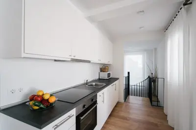 a kitchen with white cabinets and a bowl of fruit on the counter at Eva Recommends Capilla de la Jura en Jerez in Jerez de la Frontera