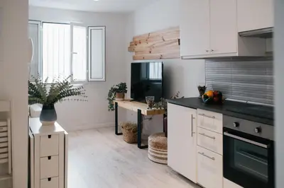 a kitchen with white cabinets and a desk at Eva Recommends Capilla de la Jura en Jerez in Jerez de la Frontera