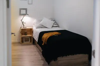 a bedroom with a bed with a black blanket at Eva Recommends Capilla de la Jura en Jerez in Jerez de la Frontera