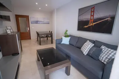 a living room with a blue couch and a table at Las Palomas 15 in Sanlúcar de Barrameda