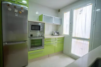 a kitchen with a stainless steel refrigerator and a window at Las Palomas 15 in Sanlúcar de Barrameda