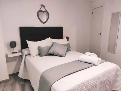 a bedroom with a large white bed with two pillows at Loft Sherry in Jerez de la Frontera