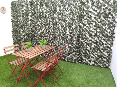 a wooden table and chairs in front of a wall at Loft Sherry in Jerez de la Frontera