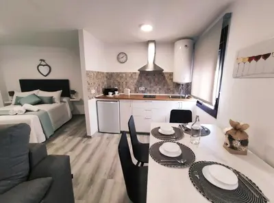 a kitchen and a living room with a table and chairs at Loft Sherry in Jerez de la Frontera