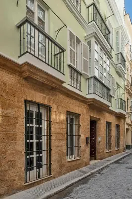 a building with balconies on the side of a street at Gadir Suites in Cádiz