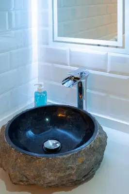 a bathroom sink with a large rock at Gadir Suites in Cádiz