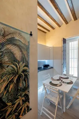 a dining room with a white table and a palm tree mural at Gadir Suites in Cádiz