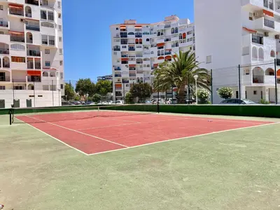 a tennis court in front of some tall buildings at ESTUDIO BLEGAMAR TERRAZA - Playa, WiFi y Aparcamiento in El Puerto de Santa María
