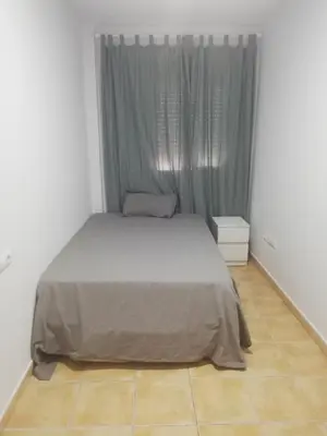 a bedroom with a bed and a window with curtains at Apartamento Conil San Diego de Alcalá in Conil de la Frontera
