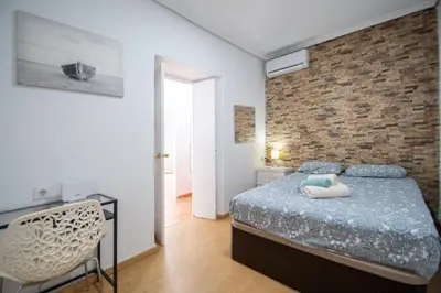 a bedroom with a bed and a brick wall at Apartment La Gitanilla terrace in Cádiz