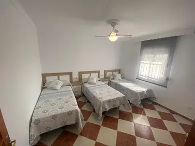 a room with two beds and a checkered floor at Casa Silvia in Cádiz