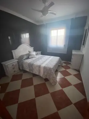 a bedroom with a bed and a checkered floor at Casa Silvia in Cádiz